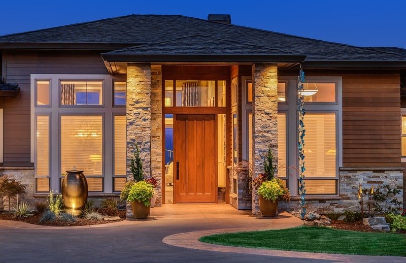 a house with a stone wall and a stone column